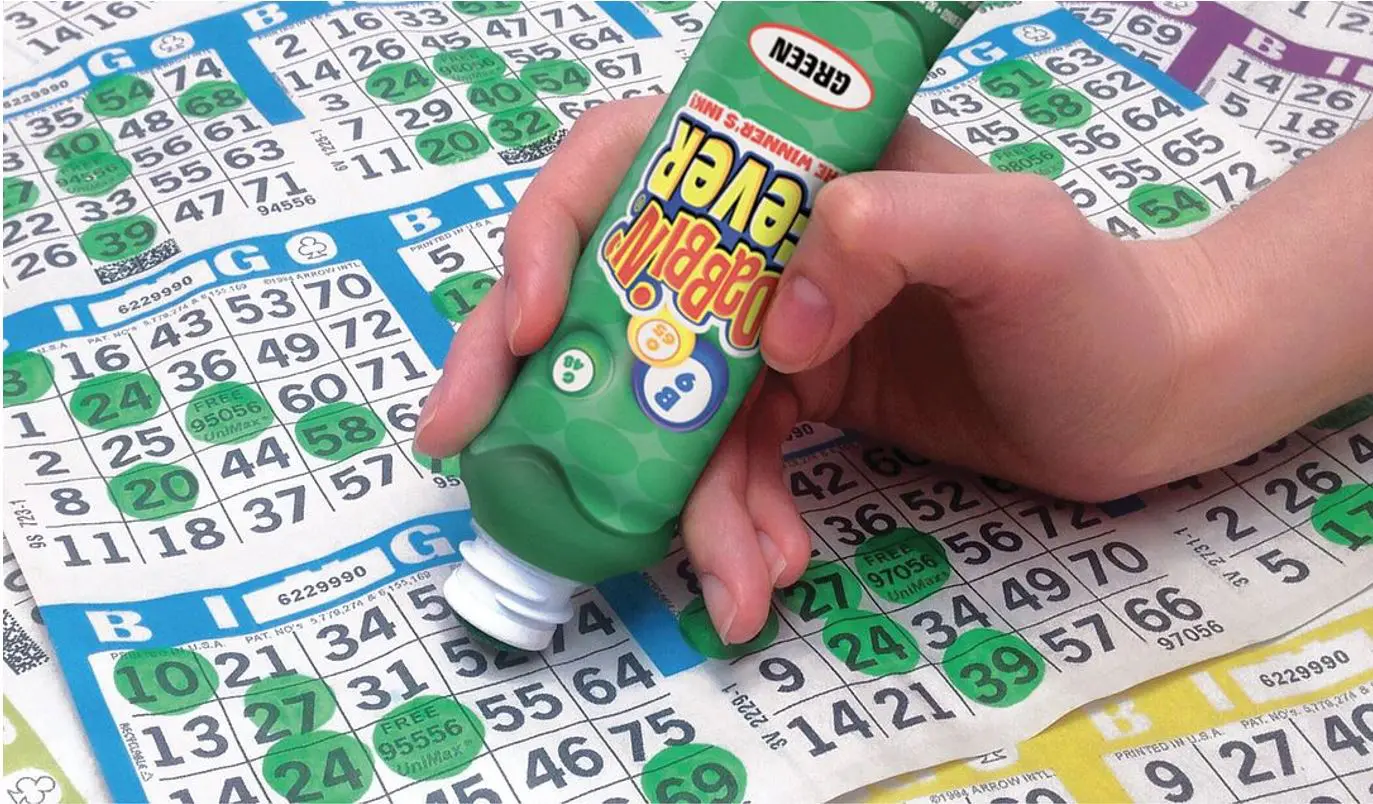 A person holding a bottle of bingo marker